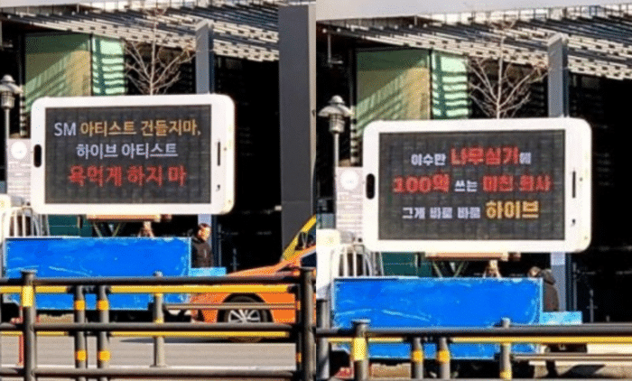 Фанаты SM Entertainment отправили грузовики с фразами протеста к зданию HYBE