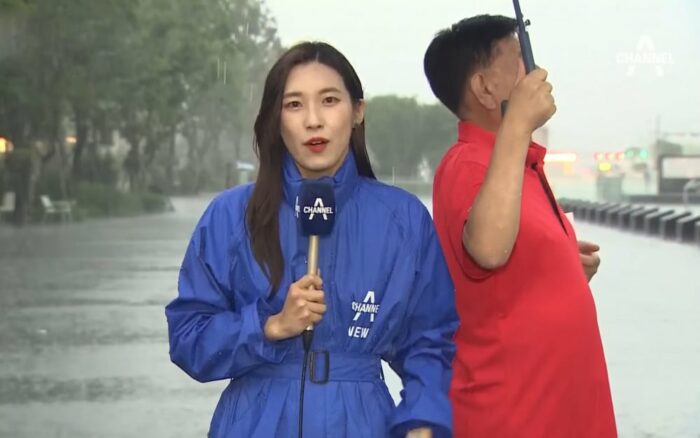 Репортер выражает благодарность мужчине, который держал над ней зонт во время дождя
