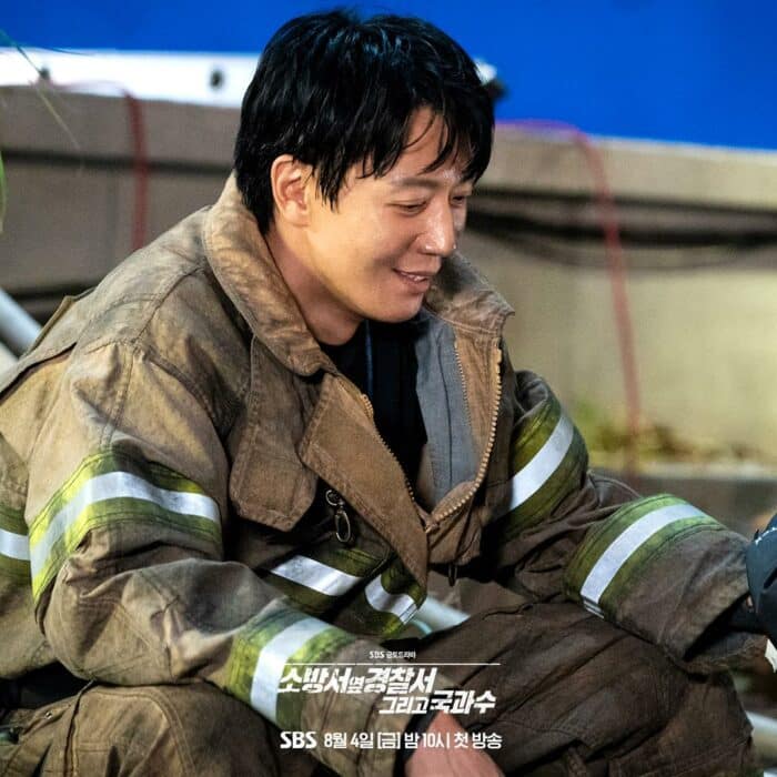 Ким Рэ Вон улыбается Гон Сын Ён, которая обрабатывает его раны, во 2 сезоне дорамы «Полицейский участок рядом с пожарной частью»