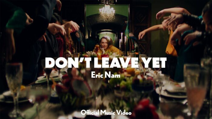 Эрик Нам наблюдает за танцем во время ужина в музыкальном клипе на песню "Don't Leave Yet"
